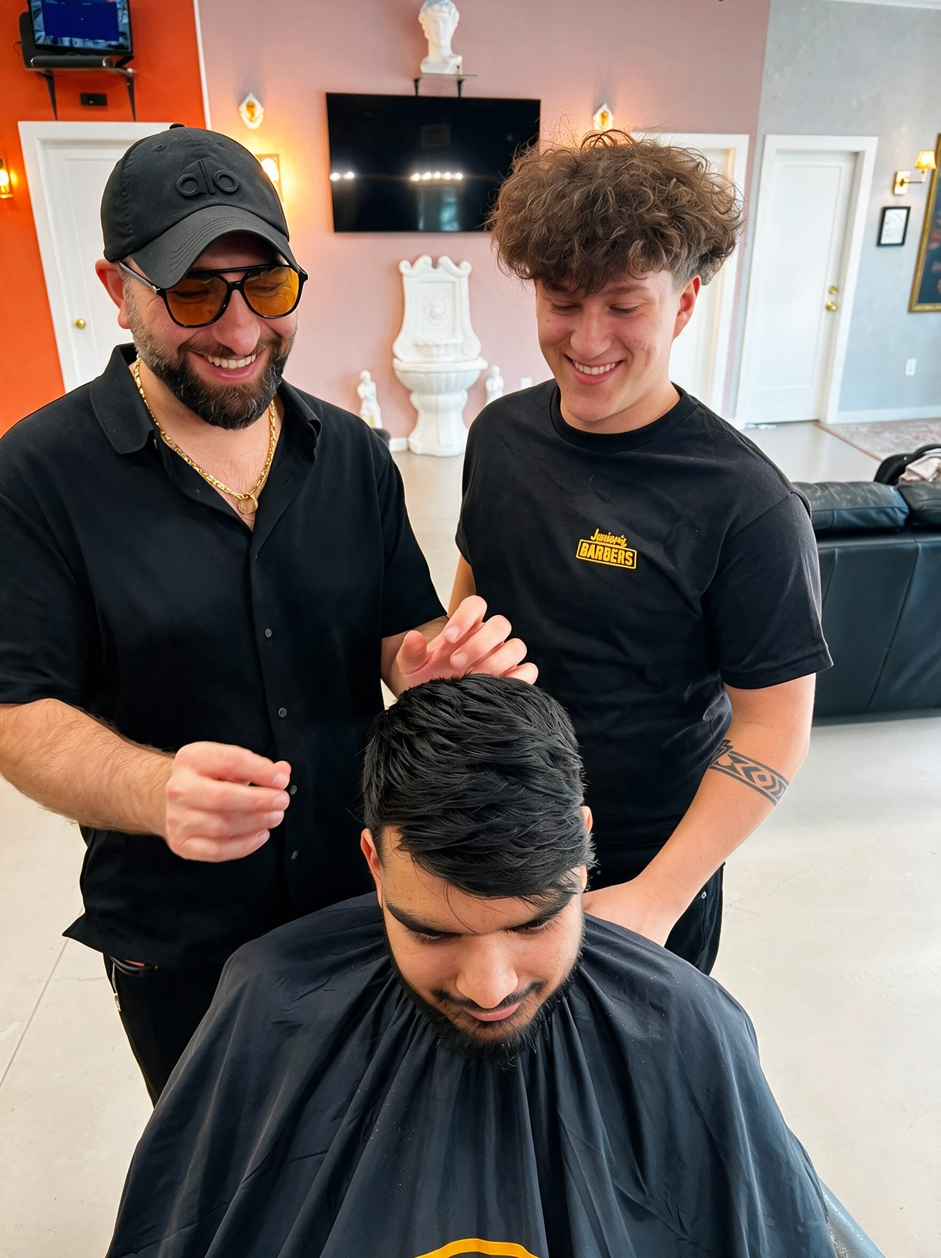 Two barbers coaching a client together on the floor